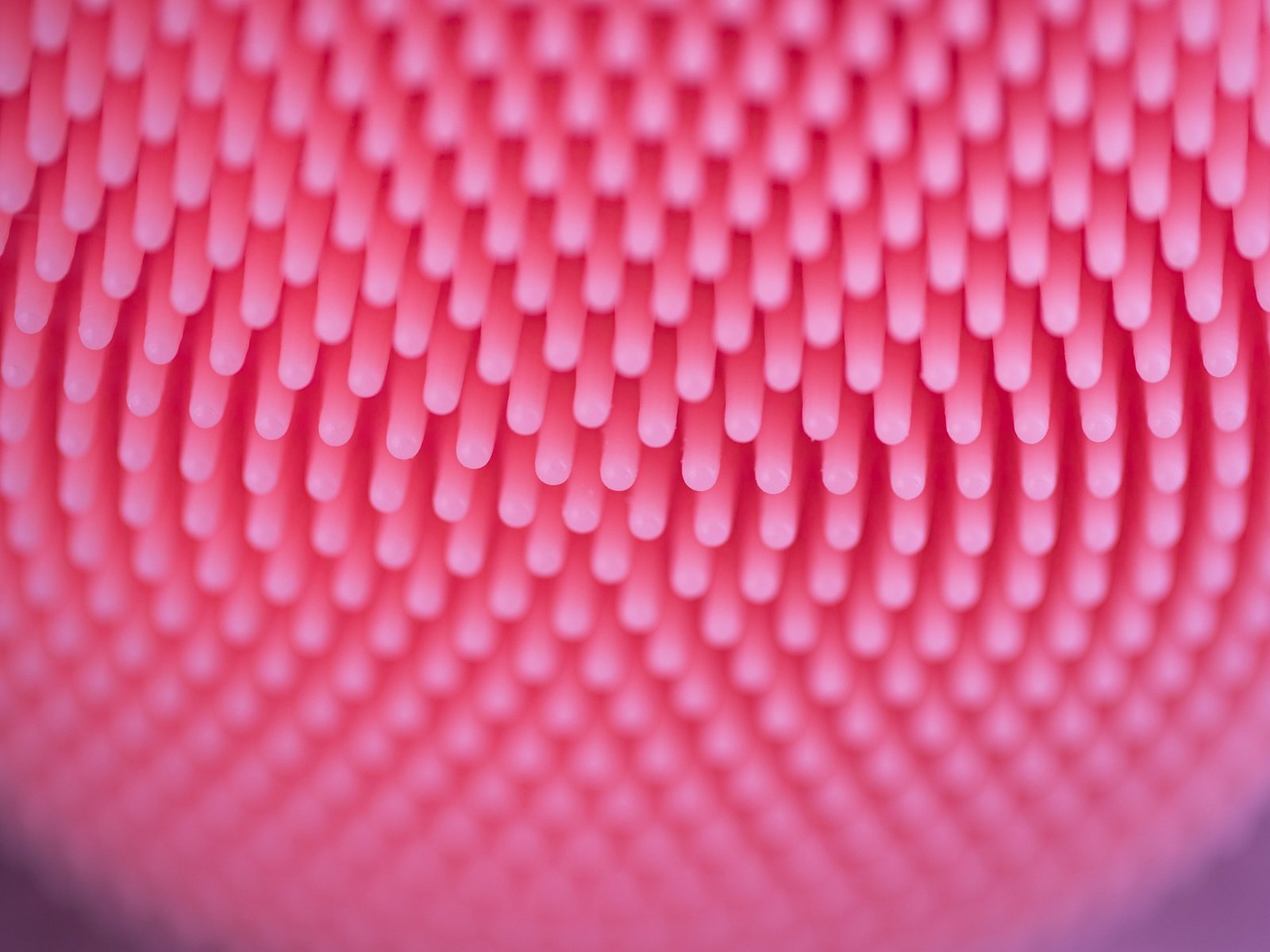 Primer plano de los puntos de silicona rosa de un cepillo de limpieza facial