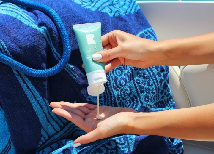 person holding white plastic tube bottle